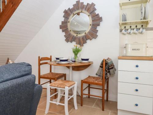 - un salon avec une table et un miroir dans l'établissement Honeymoon Cottage, à Bideford