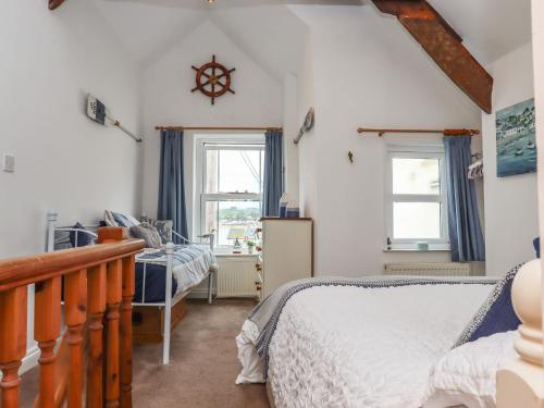 une chambre avec un lit et deux fenêtres dans l'établissement Honeymoon Cottage, à Bideford