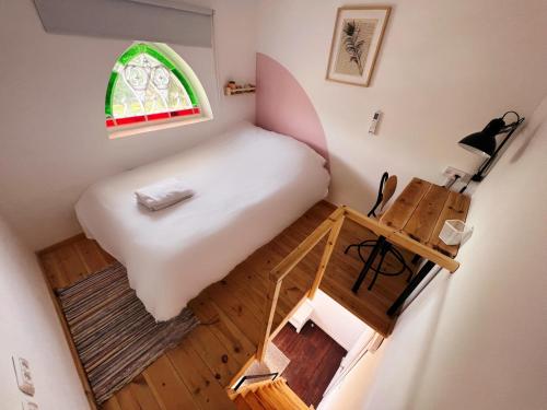 Kleines Zimmer mit einem Bett und einem Tisch in der Unterkunft Ajami Guest House in Tel Aviv