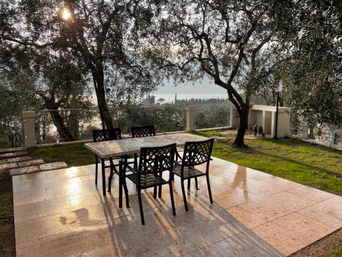 una mesa y sillas en un patio con árboles en Cochetto's House in Malcesine, en Malcesine