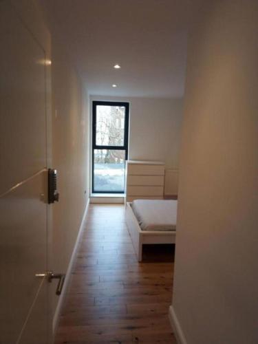 a room with a bedroom with a bed and a window at Luxury Penthouse Apartment ( Private Gated) in London