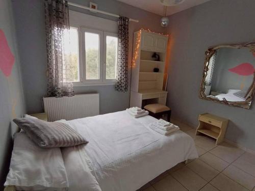 a bedroom with a white bed and a mirror at Lil' fam farm home - Beach 10min in Agios Ioannis