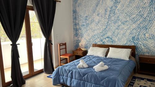 a bedroom with a bed with two stuffed animals on it at Kanalis Houses in Avlonárion