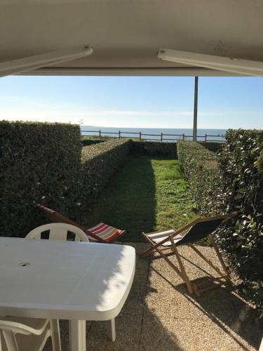 une table et des chaises avec vue sur la plage dans l'établissement Les Rochers de Vallières, à Saint-Georges-de-Didonne