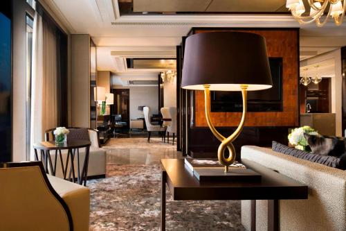 a living room with a couch and a lamp on a table at JW Marriott Dongdaemun Square Seoul in Seoul