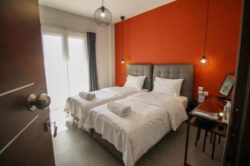 a bedroom with a large bed with an orange wall at LA CASA DE PROFESOR 2 in Kalabaka