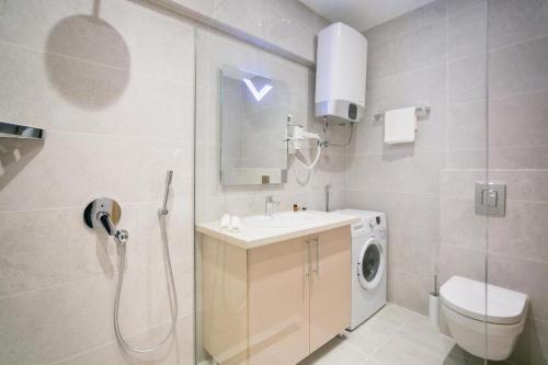 a bathroom with a sink and a washing machine at Apartments Lux sea view in Budva