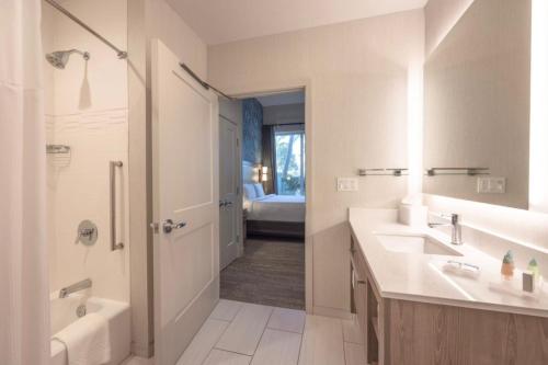 a bathroom with two sinks and a shower and a tub at Residence Inn Palm Beach Gardens in Palm Beach Gardens
