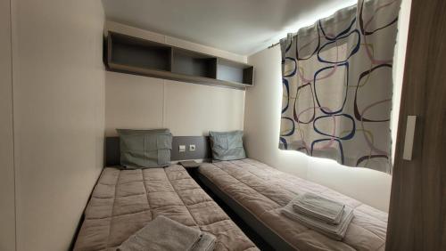 a small bedroom with a bed and a window at MobilHome Laura EUROPAPARK 20min in Boofzheim