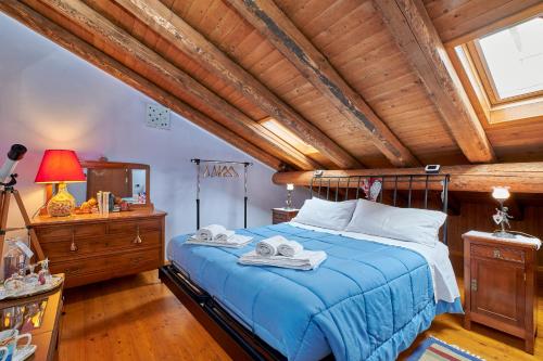 a bedroom with a blue bed with a wooden ceiling at B&B Adelche in San Giovanni Bianco