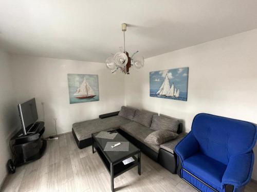 ein Wohnzimmer mit einem Sofa und einem blauen Stuhl in der Unterkunft Riviera in Rijeka