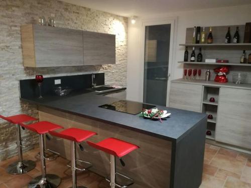 una cocina con barra con taburetes rojos en Billiard House en Romano D'Ezzelino
