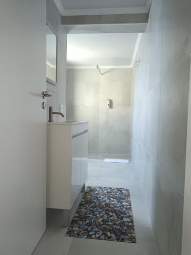 a bathroom with a shower and a sink and a rug at Casa do Lameirinho in Angra do Heroísmo