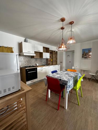 uma cozinha e sala de jantar com mesa e cadeiras em Maiolica House em Cefalù