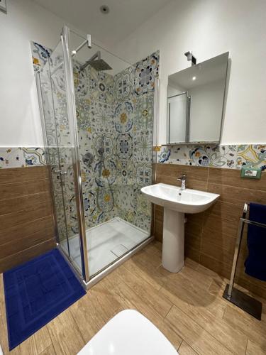 uma casa de banho com um chuveiro e um lavatório. em Maiolica House em Cefalù