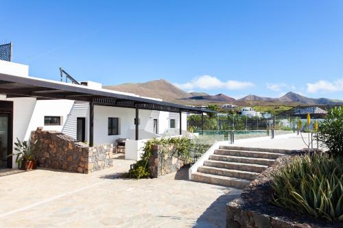 a house with stairs and mountains in the background at Mana EcoRetreat in Las Breñas
