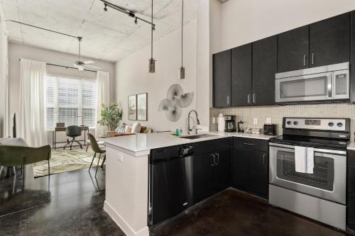 a kitchen with black and white appliances and a dining room at Lodgeur at Elan Med Center in Houston