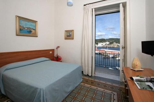 a bedroom with a bed and a door to a balcony at Locanda Mari in Ponza