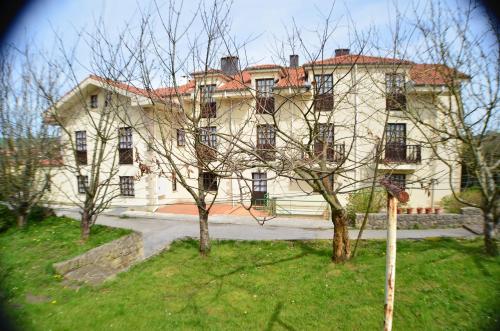 a large white house with a tree in front of it at Hotel Salldemar in Santillana del Mar