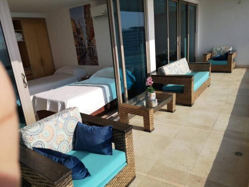 a hotel room with a balcony with a bed and chairs at Luxury apartment in Morros - Cartagena de Indias in Cartagena de Indias