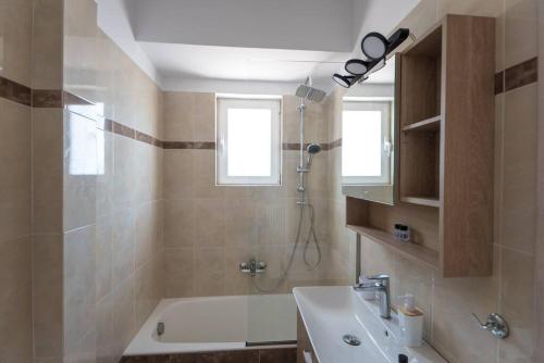 a bathroom with a tub and a sink and a shower at Athens & Acropolis View 7th Floor Apartment in Athens