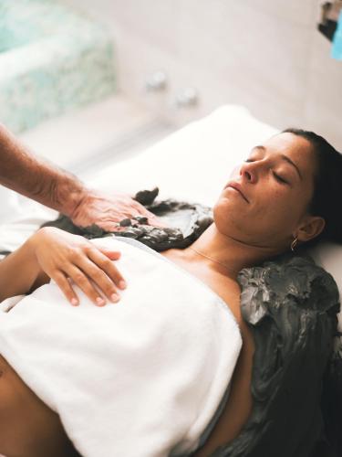 a woman laying in a hospital bed getting a massage at Hotel Terme Millepini in Montegrotto Terme