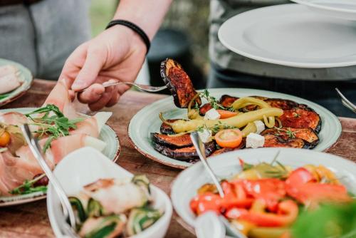 a person eating food on a table with plates of food at Landhotel Altmann in Hörstel