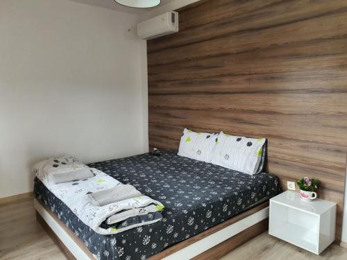 - une chambre avec un lit et une tête de lit en bois dans l'établissement Бадевски рай- къща София, à Veliko Tarnovo