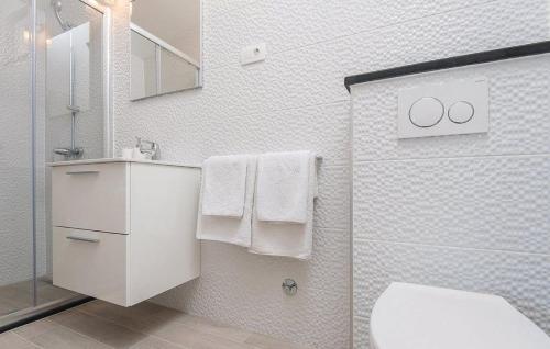 Un baño con inodoro y ducha con toallas. en Apartment ARGO on the beach, en Sreser