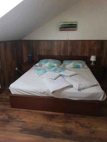 a bed with white sheets and pillows on it at Twins in Hurbanovo