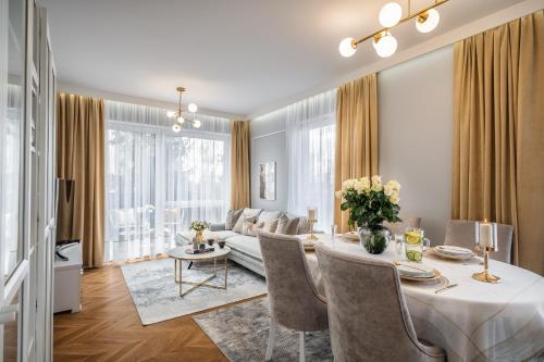 a dining room and living room with a table and a couch at Apartmenteight in Toruń