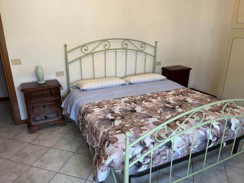 1 dormitorio con cama, mesita de noche de madera y cama sidx sidx sidx sidx en Aria di casa affittacamere, en Badesse