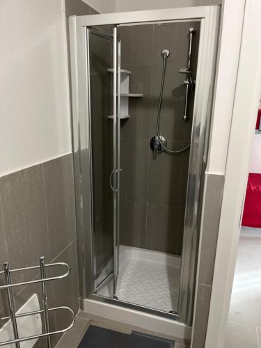 a shower with a glass door in a bathroom at Appartamento bilocale vista mare FT7 in Cascabraga