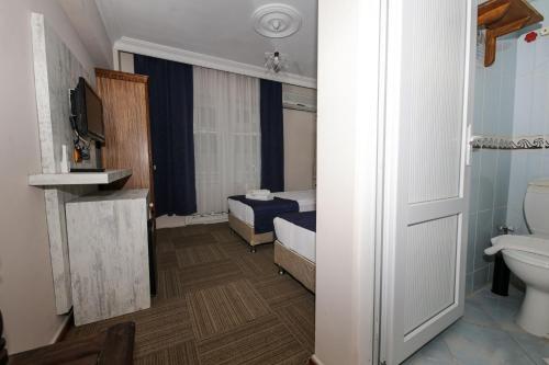 un piccolo bagno con letto e servizi igienici di MELODİ BUTİK OTEL a Edremit