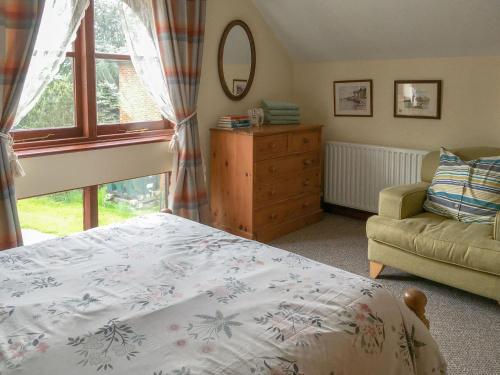 a bedroom with a bed and a chair and a window at Pheasant in Welney