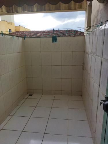 a room with white tiled floors and a roof at Apartamento de luxo com 2 quartos, sala com sacada, cozinha área de serviço e 1 banheiro social. in Ipatinga