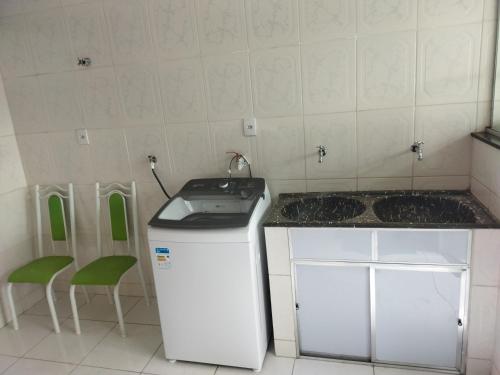 a kitchen with a counter and a sink and a dishwasher at Apartamento de luxo com 2 quartos, sala com sacada, cozinha área de serviço e 1 banheiro social. in Ipatinga