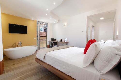 una camera con un grande letto e una vasca da bagno di YourHome - Lidia Rooms & Suites a Sorrento
