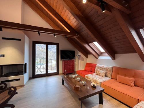 ein Wohnzimmer mit einer Couch und einem Tisch in der Unterkunft BPIRINEOS-Aigualluts in Benasque