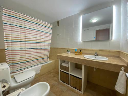 ein Badezimmer mit Waschbecken, Toilette und Spiegel in der Unterkunft RESIDENCIAL JARDINES DEL TEIDE, 126 in Puerto de la Cruz