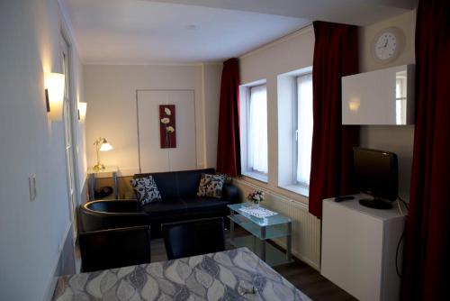 een woonkamer met een bank en een televisie bij Appartementen Vouwere in Mechelen