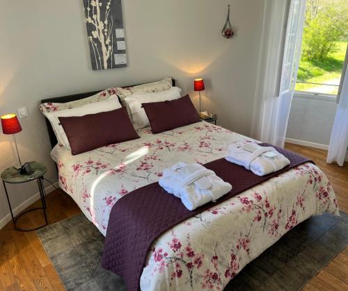 une chambre avec un lit avec deux serviettes dessus dans l'établissement Ancien Haras de la Tour, à Lamothe-Landerron