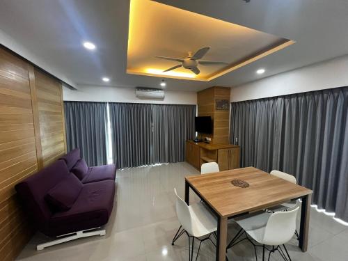 a living room with a table and a ceiling fan at Patong Beach Top Location in Patong Beach