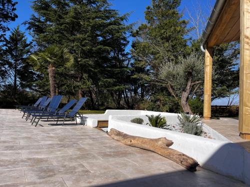 ein Blockhaus auf einer Terrasse mit Stühlen und Bäumen in der Unterkunft Villa Martinière in Saint-Georges-des-Côteaux