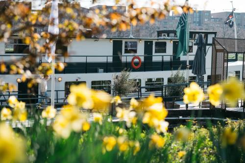 a boat in a harbor with yellow flowers at Botel Maastricht in Maastricht