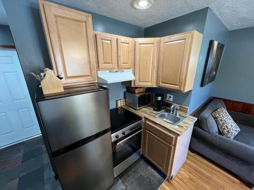 a small kitchen with a refrigerator and a sink at Homestead Inn - Blowing Rock in Blowing Rock