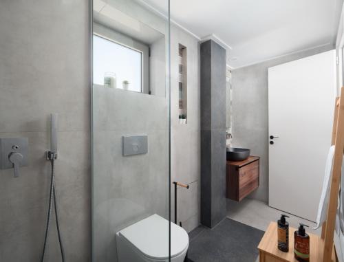 een badkamer met een toilet en een glazen douchedeur bij The H Experience - Stylish 2BD apt with balcony in Heraklion center in Heraklion