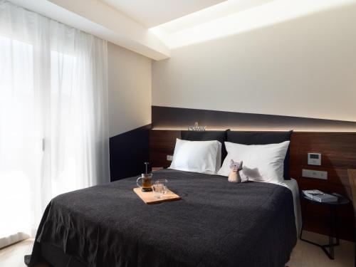 een slaapkamer met een bed met een dienblad met eten erop bij The H Experience - Stylish 2BD apt with balcony in Heraklion center in Heraklion