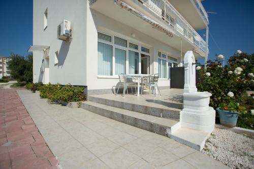 une maison avec des escaliers, une table et des chaises dans l'établissement Beach Studio Apartment Ivana, à Kaštela