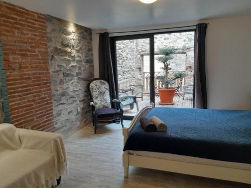 a bedroom with a bed and a brick wall at Loft vue montagne in Rigarda